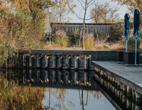Drei Männer in traditionellen historischen Uniformen stehen vor einem Gebäude mit vergitterten Fenstern und unterhalten sich.