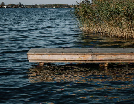 Eine Person mit Kappe inspiziert einen Edelstahltank in einer industriellen Umgebung mit gefliesten Wänden.