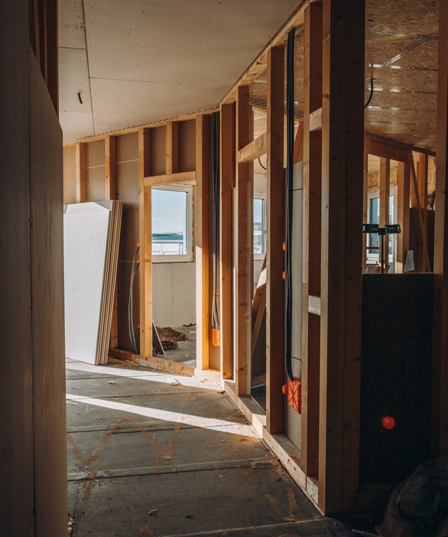 Nahaufnahme einer grünen Holztür mit diagonalen Paneelen und sichtbaren Anzeichen von Abnutzung und abblätternder Farbe.