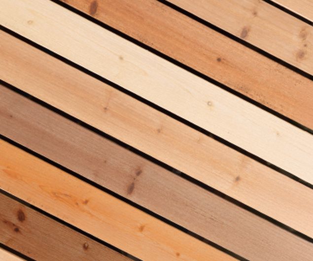 Diagonale Holzbretter in verschiedenen Brauntönen mit sichtbarer Maserung und Ästen.