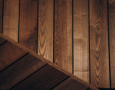 Holzbretter in vertikalen und diagonalen Mustern mit unterschiedlichen Brauntönen.